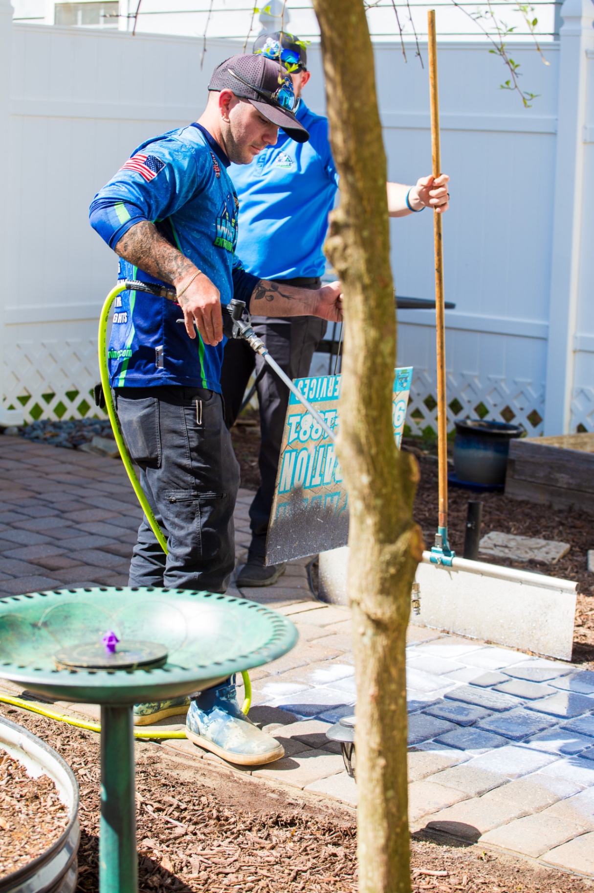 Woody’s Home Services technicians cleaning outdoor paver stones